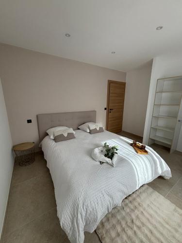 - une chambre avec un grand lit blanc orné de fleurs dans l'établissement NOUVEAUTE !!! Villa Moderne de 4 chambres, piscine chauffée et vue panoramique, à Apt