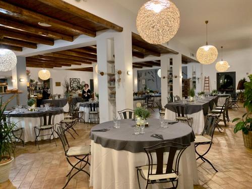 a dining room with tables and chairs and chandeliers at Agriturismo La Terrazza su Farfa in Castelnuovo di Farfa