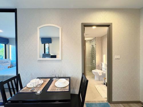a dining room with a table and a bathroom at Digital Nomad Home Away With Pool & Gym in Nai Yang Beach
