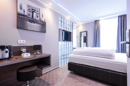 a hotel room with a bed and a television at Stay-Inn Bielefeld Zentrum in Bielefeld