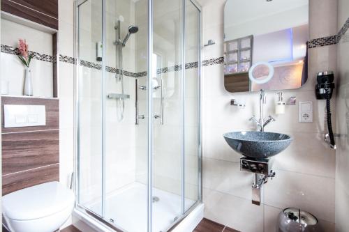 a bathroom with a glass shower and a sink at Stay-Inn Bielefeld Zentrum in Bielefeld