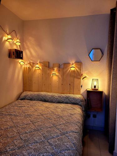 - une chambre dotée d'un lit avec des lumières sur le mur dans l'établissement Location Frontignan Plage, à Frontignan