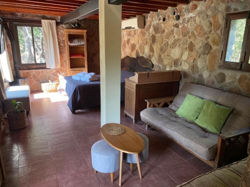 a living room with a couch and a table at Puesto de Montaña - Casa con pileta privada in Los Hornillos