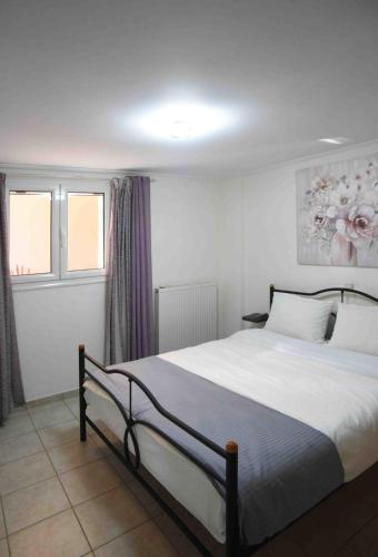 a bedroom with a bed and two windows at villa ioanna eretria in Eretria