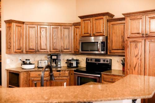 a kitchen with wooden cabinets and a microwave at Luxury 4br home, 2 king,1 queen, 3bed, 4tv in Wichita Falls