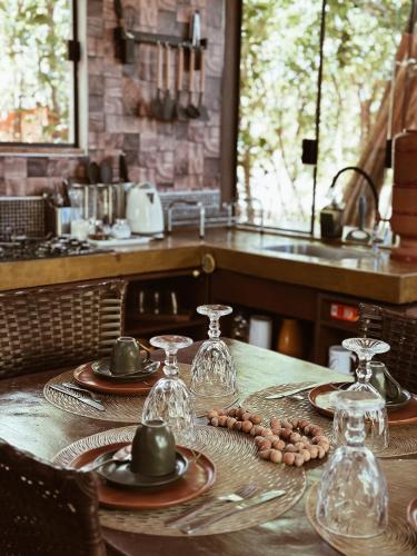 a table with plates and wine glasses on it at Vila Abaton in Alto Paraíso de Goiás