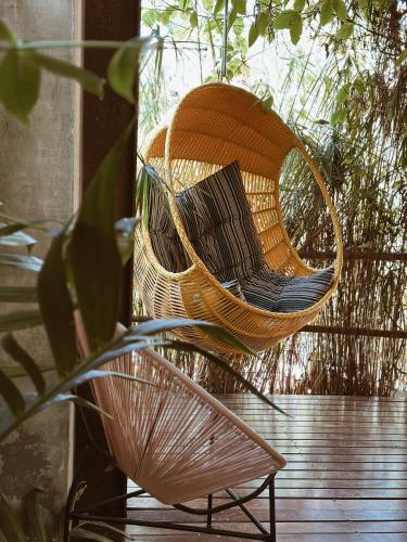a wicker chair sitting on top of a porch at Vila Abaton in Alto Paraíso de Goiás