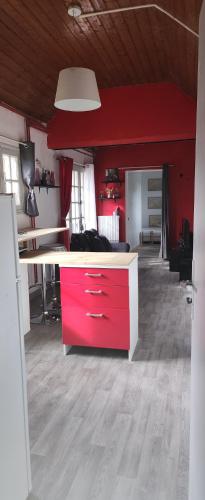een keuken met een rood eiland in een kamer bij Le coquelicot in Maimbeville