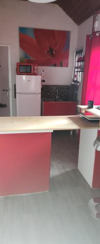 een keuken met rode kasten en een aanrecht bij Le coquelicot in Maimbeville
