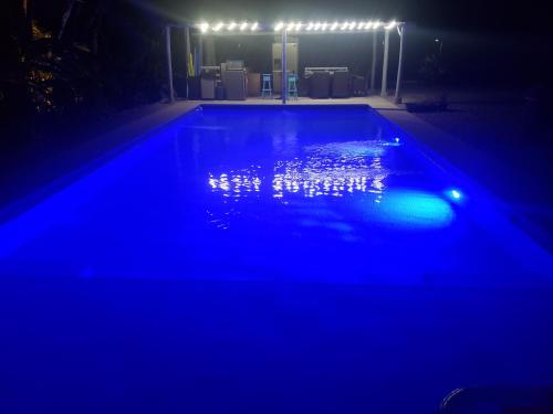 an empty swimming pool at night with blue lights at Casa Vistas del Rio in Sámara