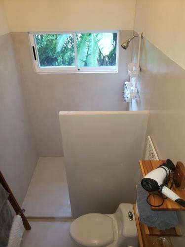a small bathroom with a toilet and a window at Casa Vistas del Rio in Sámara