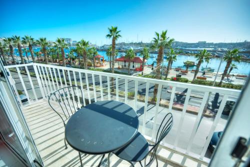 a balcony with a chair and a view of the water at Seafront 2 bedroom with balcony & jacuzzi GOGZR-6 in Il-Gżira