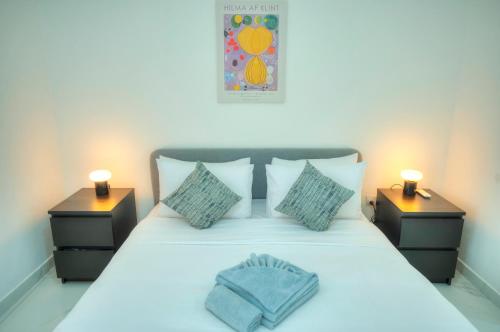 a bedroom with a white bed with two night stands at Seafront 2 bedroom with balcony & jacuzzi GOGZR-6 in Il-Gżira