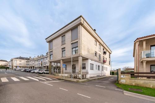 an apartment building on the side of a street at White Tree By Arca Hostel in O Pedrouzo