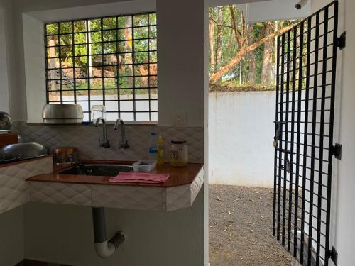 a kitchen with a sink and a window at The White House in Thodupuzha