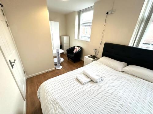 a bedroom with a bed with two towels on it at Mos' Place in Manchester