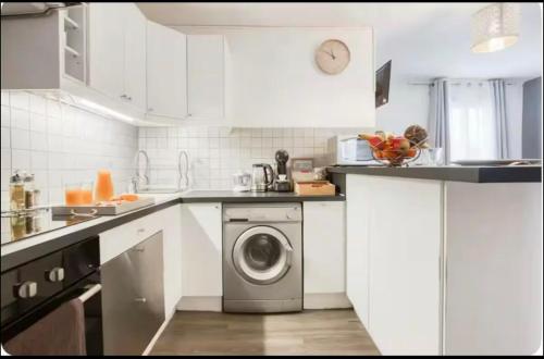 une cuisine blanche avec une machine à laver à l'intérieur dans l'établissement 2 Studio cozy à 30minutes de Paris centre, à Houilles