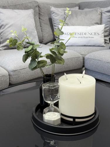 a table with two candles and a vase with a plant at A home away from home in Manchester