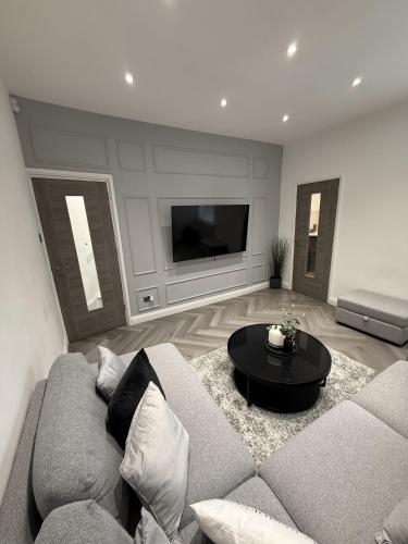 a living room with a couch and a table at A home away from home in Manchester