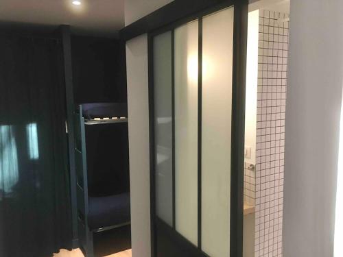 d'une armoire en verre avec une chaise bleue. dans l'établissement location-cote-basque fr - Studio au golf du phare de Biarritz - piscine, plage, golf, parking, à Anglet