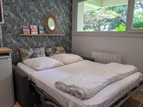 un lit dans une chambre avec une fenêtre dans l'établissement location-cote-basque fr - Studio au golf du phare de Biarritz - piscine, plage, golf, parking, à Anglet