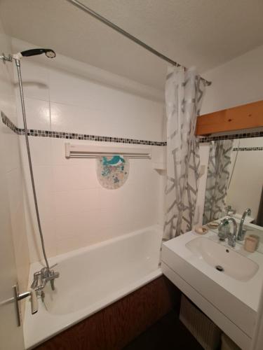 une salle de bain avec un lavabo, une baignoire et une douche dans l'établissement Appartement 5 personnes 31 m2 une chambre à Montchavin, proche pistes, commerces, balcon avec vue montagne, à La Plagne Tarentaise
