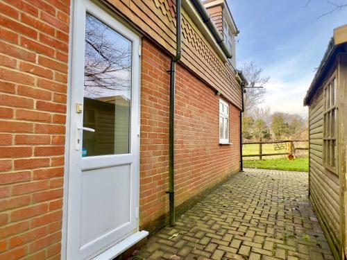 a brick building with a white door and a brick walkway at Quiet Flat near Biggin Hill Airport Parking 1 Bed in Westerham