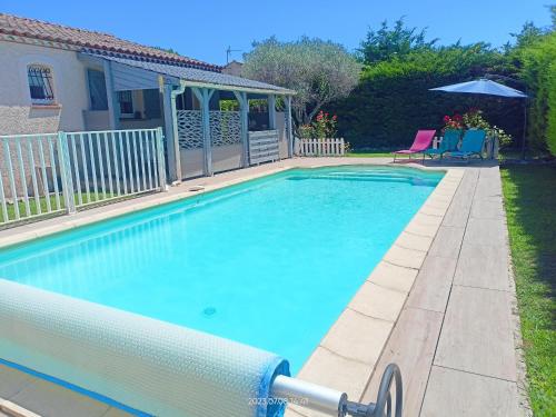 une piscine avec de l'eau bleue dans une cour dans l'établissement Maison avec grande piscine près de Nîmes, à Redessan