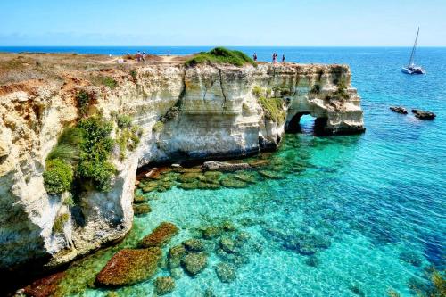 a cliff in the ocean with a boat in the water at Il Gelso in Lecce