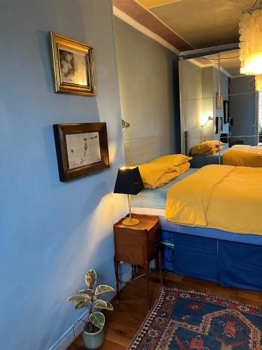 une chambre avec deux lits et un miroir au mur dans l'établissement Cozy Montmartre apartment with views over rooftops, à Paris