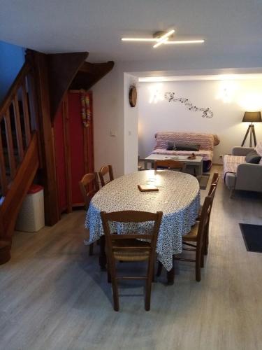 - une salle à manger avec une table, des chaises et un lit dans l'établissement Gîte le Jaya, à Saint-Georges-de-Luzençon