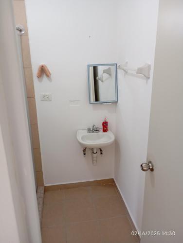 a bathroom with a sink and a mirror at Casa arcilla clima total Starlink zona Aeropuerto in Villa Juárez