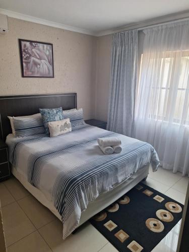 a bedroom with a large bed and a window at Caribbean Estate Guest House B11 in Port Edward