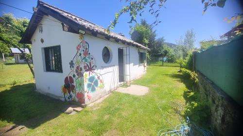 Una casa con una pintura en el costado. en Ty Hapus, en El Bolsón