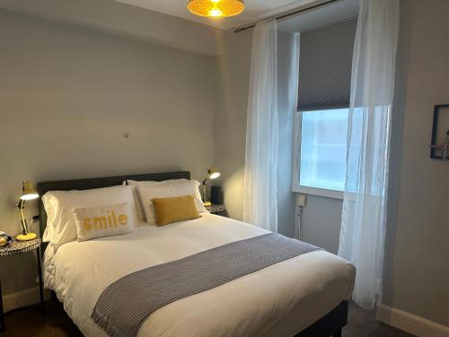 a bedroom with a bed with pillows and a window at Comfortable one-bedroom apartment Free parking space in Edinburgh