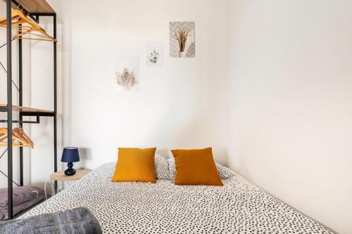 - une chambre avec un lit et deux oreillers orange dans l'établissement La Grande Motte, Port, T2, 48m2, climatisé, 3 étoiles, à La Grande Motte