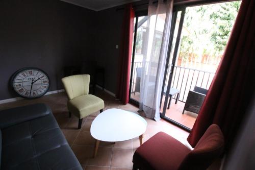 a living room with a clock and a couch at Casa Bonita in Ablekuma