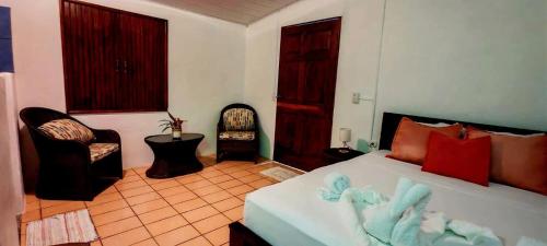 a bedroom with a bed and two chairs in it at LagunaVista Villas in Carate