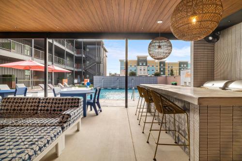 um pátio com um bar com cadeiras e uma piscina em The Mercer em New Braunfels