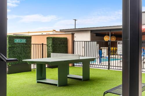 uma mesa verde e um banco em frente a um prédio em The Mercer em New Braunfels