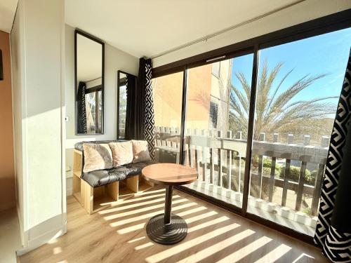 Cette chambre dispose d'une table, d'une chaise et d'un balcon. dans l'établissement Village Naturiste - La Venus - Parking WiFi, au Cap d'Agde