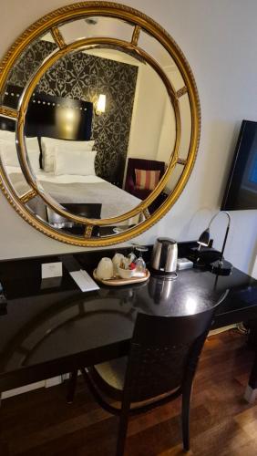 a mirror on a desk with a bed in a room at Home Hotel Arcticus in Harstad