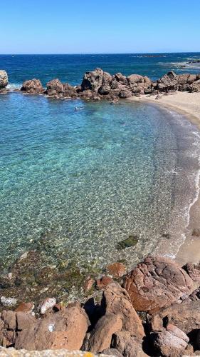 a beach with rocks and the water at Da Marta Appartamento VISTA MARE MOZZAFIATO ISOLA ROSSA in Cascabraga