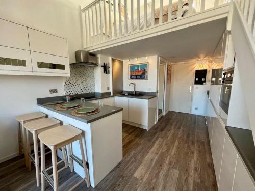 a kitchen with white cabinets and a kitchen island with stools at Nid du port in Grimaud