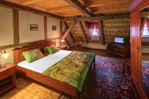 a bedroom with a large bed in a wooden house at Hradní Bašta in Bečov nad Teplou