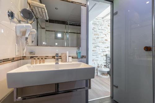 a bathroom with a white sink and a shower at Galaxy Hotel Naxos in Naxos Chora