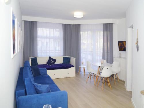 a living room with a blue couch and a table at Apartment in Dziwnówek near Baltic Beach in Dziwnówek