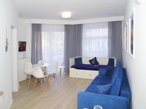 a living room with a blue couch and a table at Apartment in Dziwnówek near Baltic Beach in Dziwnówek