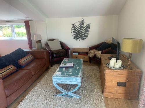 a living room with a couch and a table at Stable End in Liskeard