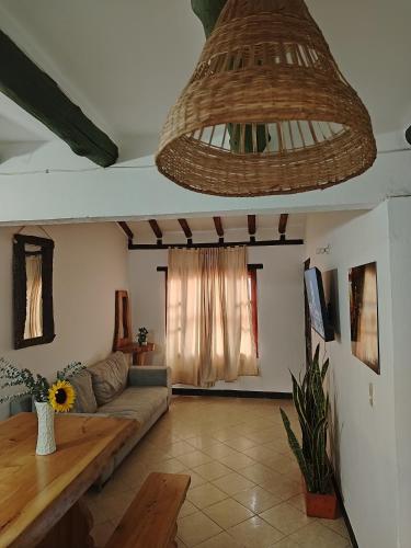 a living room with a couch and a chandelier at Villa Girasol in Villa de Leyva